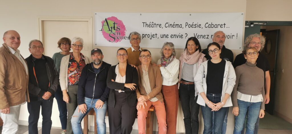 Les membres d'Arts en Scènes devant la banderole de l'association